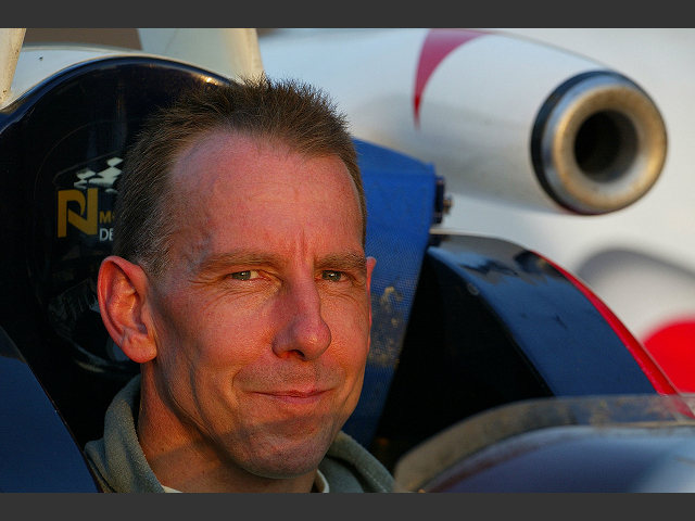 A rueful smile from Andy Wallace as he and the car are towed back to the pits