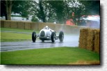 Emanuele Pirro im Auto Union C-Typ im Regen von Goodwood. Strohballen sind der einzige Schutz zwischen Autos und Fahrern. 