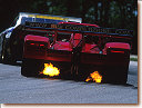 The Risi Ferrari spits flames as van de Poele downshifts for turn 6